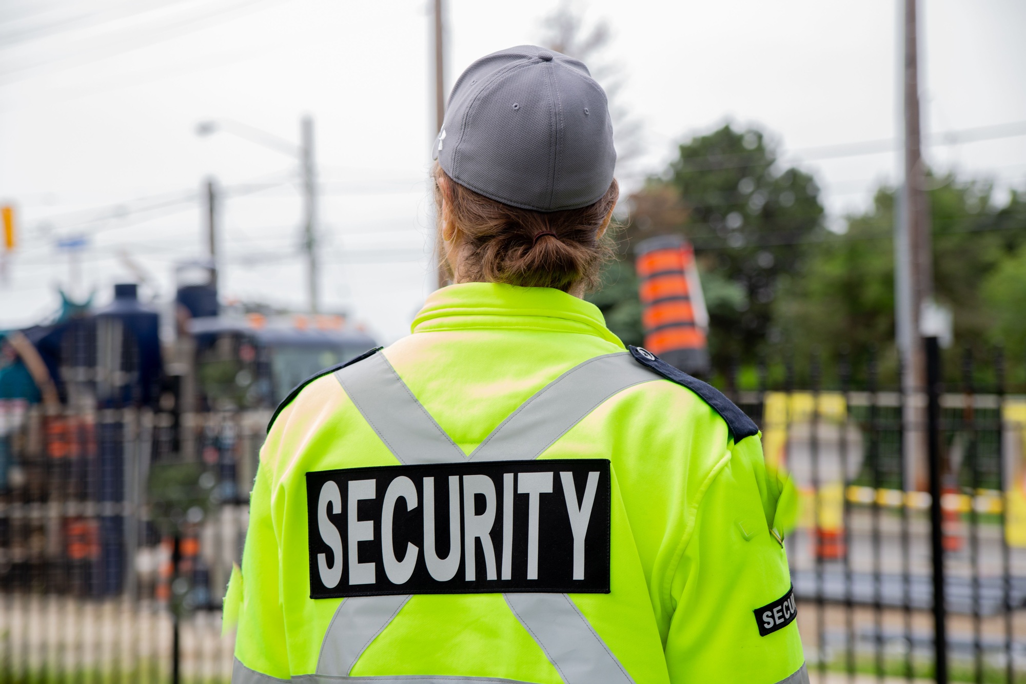 Closeup back shot of a security guard patrolling the street next to the construction area